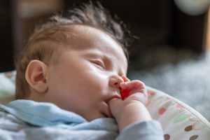 Trẻ 2 tháng tuổi mút tay khi ngủ